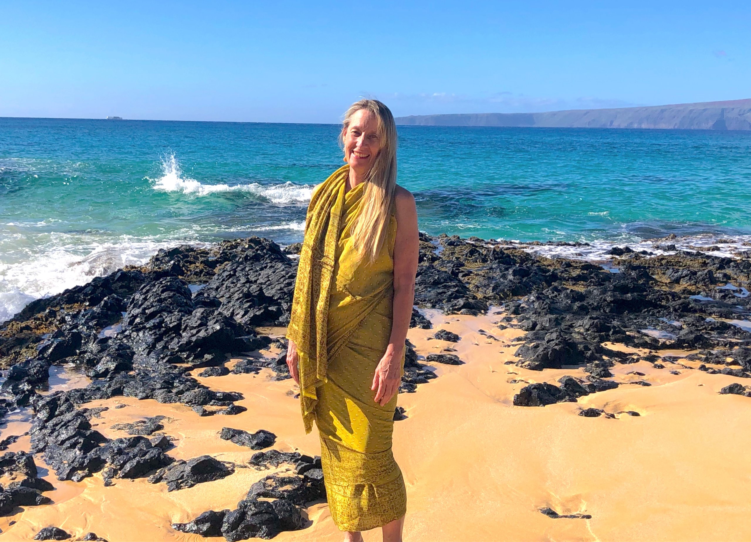 Rose standing on a sunlit volcanic beach on the Big Island of Hawai'i